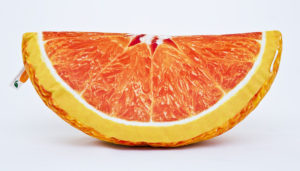 Poduszka dekoracyjna w kształcie ćwiartki pomarańczy.